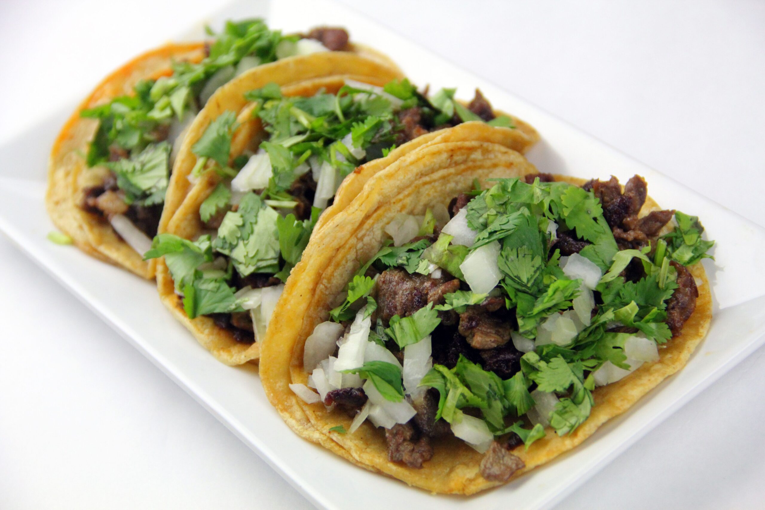 Mouth-watering beef tacos topped with fresh cilantro and onions.